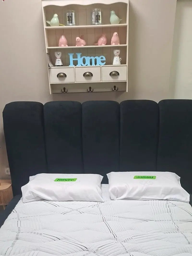 מיטה זוגית מרופדת בגוון שחור עם גב גבוה בעיצוב קשתות