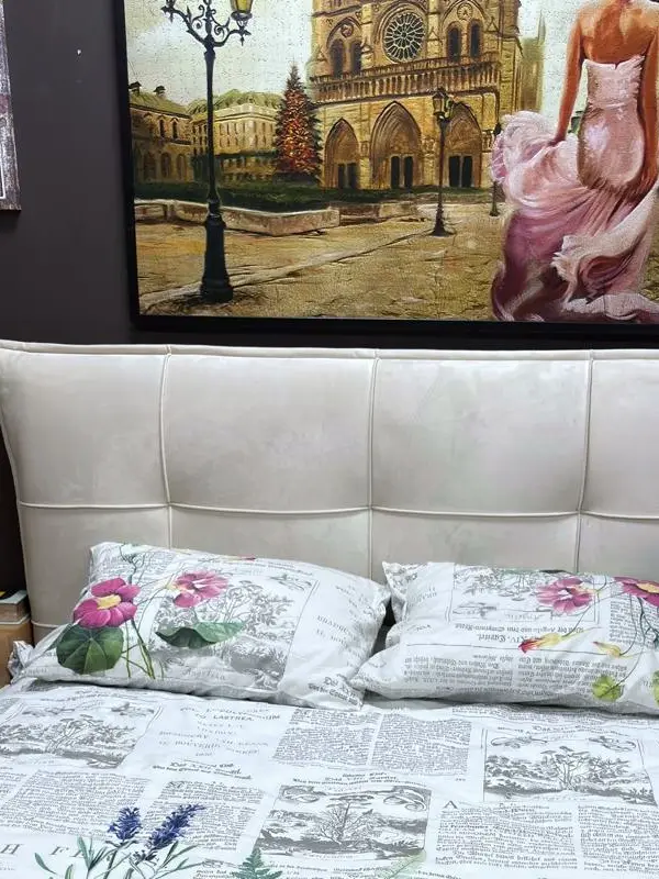 מיטה זוגית מרופדת בגוון שמנת עם גב גבוה בעיצוב ריבועים מרופדים