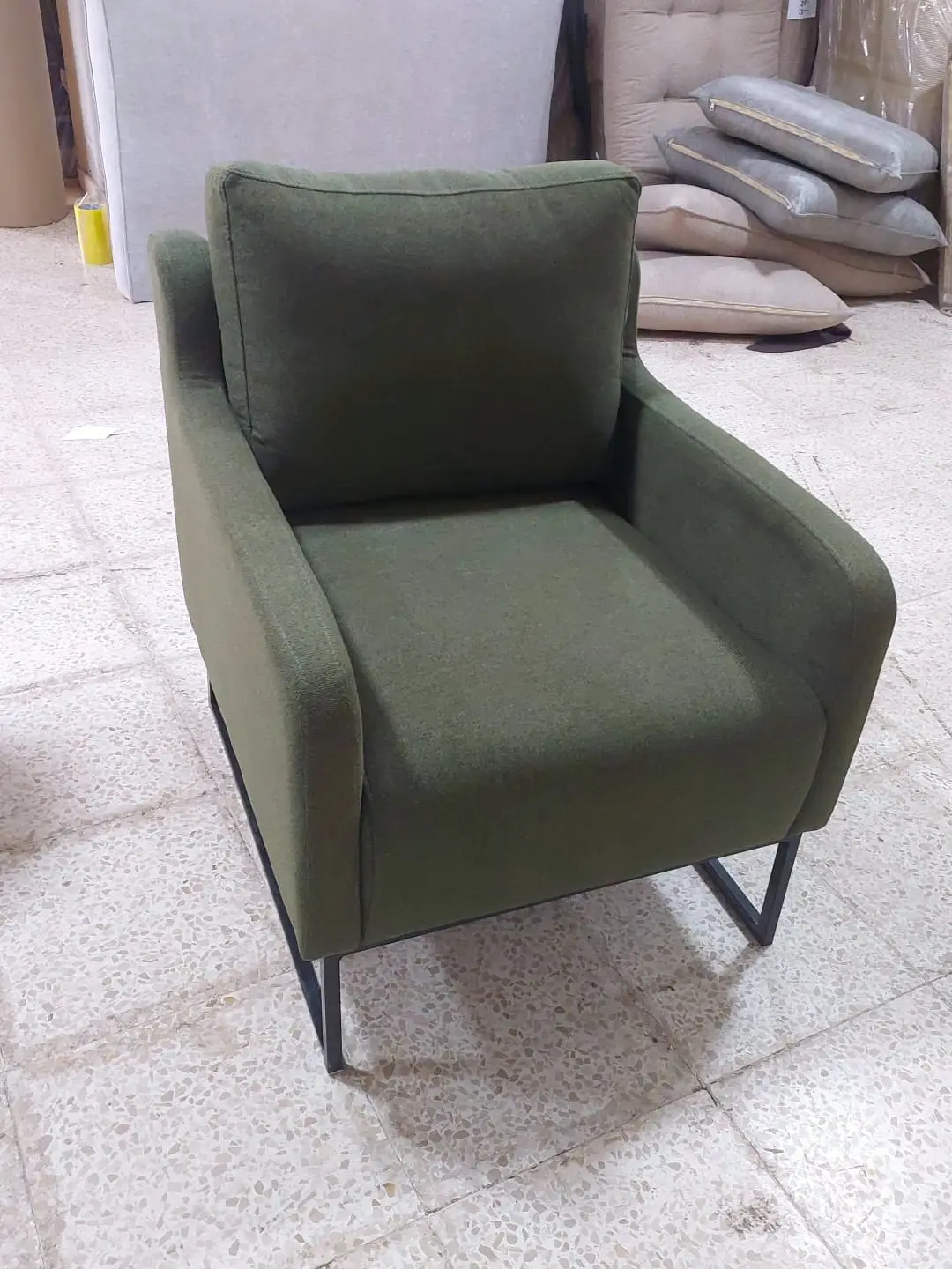 כורסה בגוון ירוק זית עם רגלי מתכת שחורות