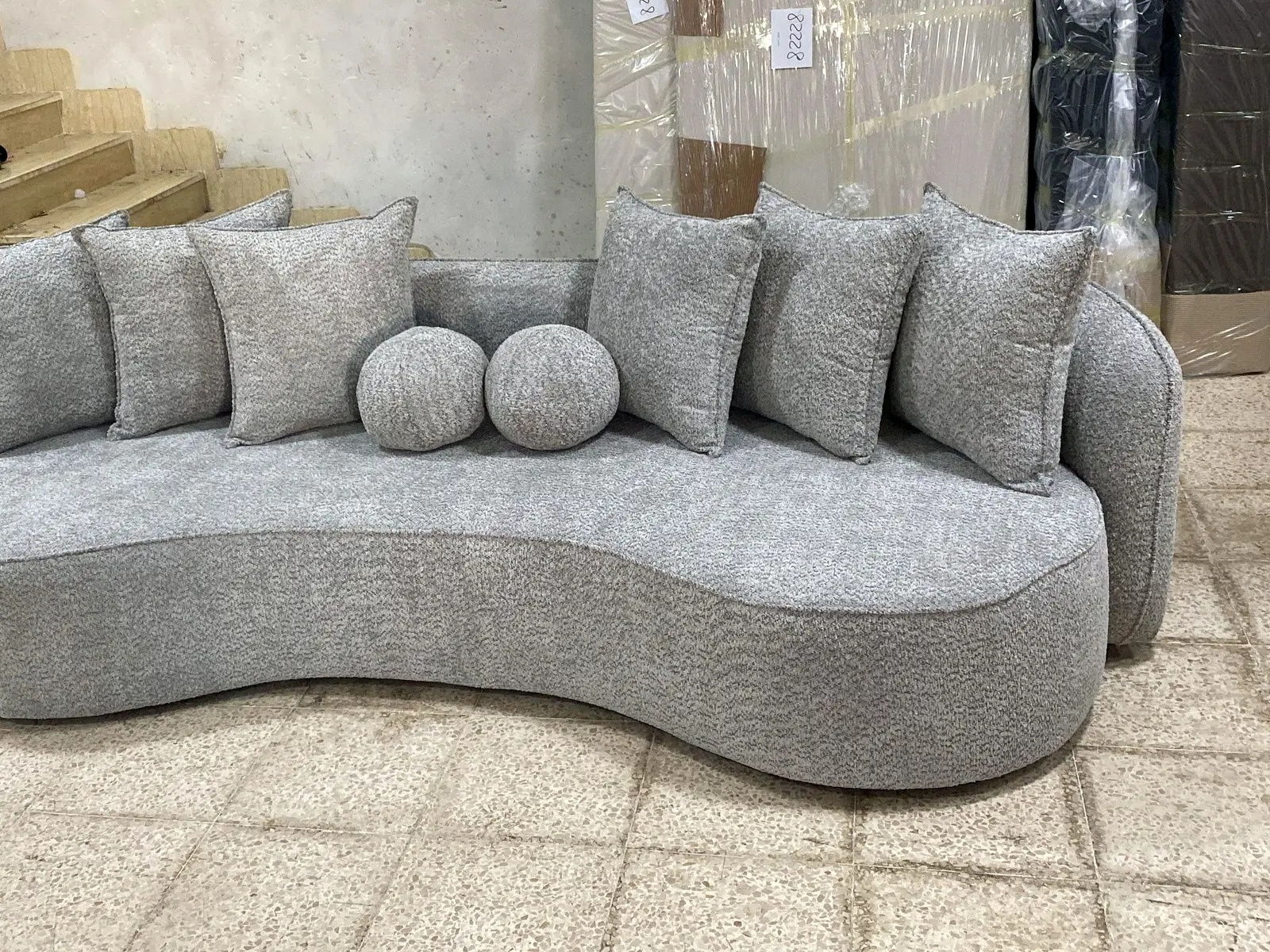 ספה בקו מעוגל בגוון אפור בהיר עם כריות גליל