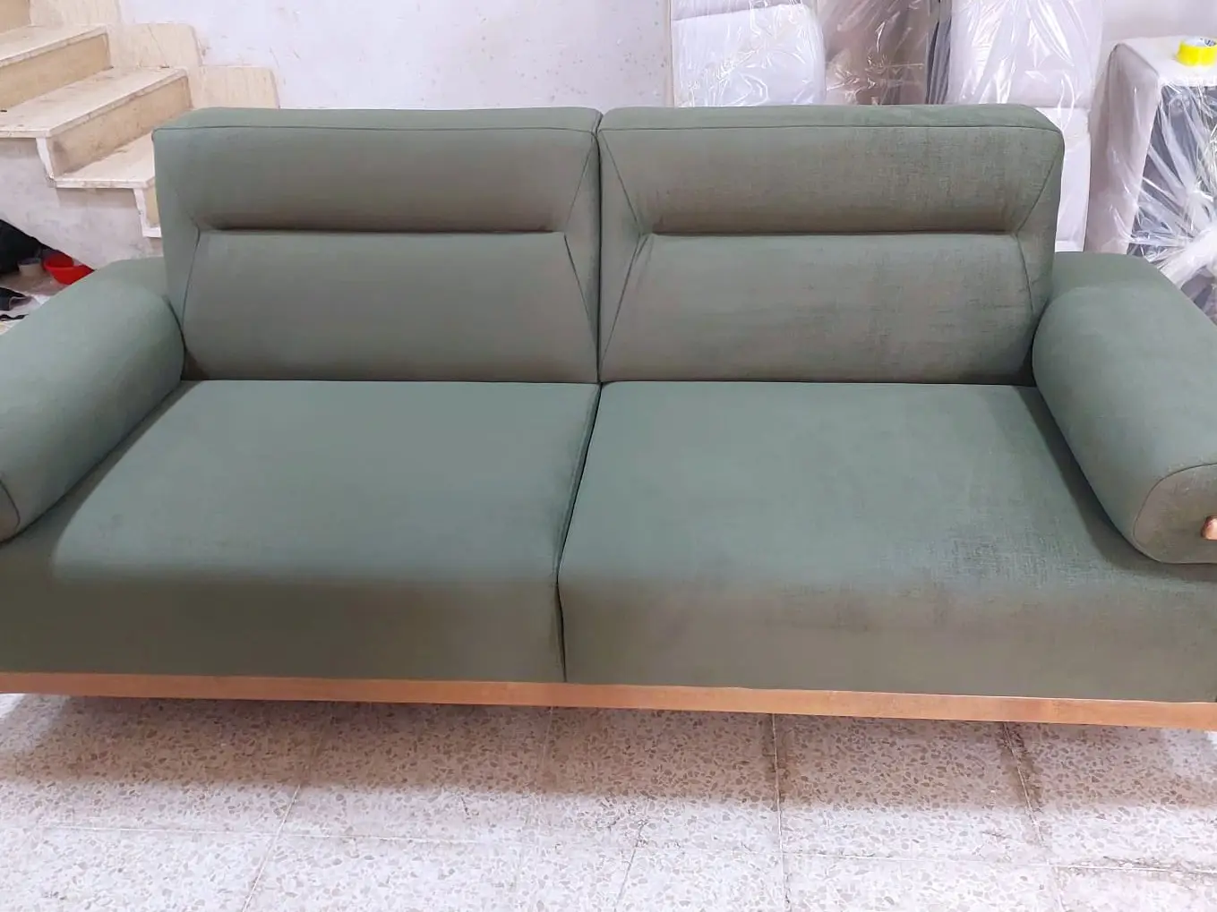 ספה בגוון ירוק זית עם מסגרת עץ חשופה