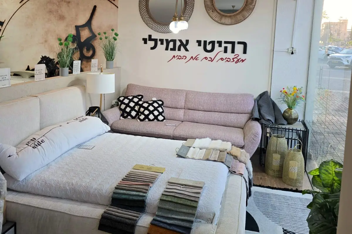 מיטה מרופדת בגוון שמנת ועליה דוגמיות בדים לבחירה, לצד ספה בגוון ורוד עתיק